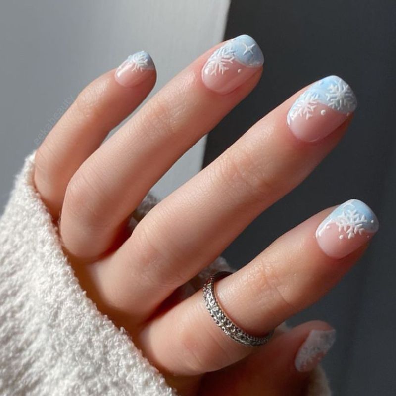 Light blue diagonal French mani with white snowflakes