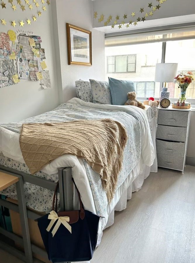 coastal dorm room bed layered with a sand beige throw blanket and coastal-colored pillows