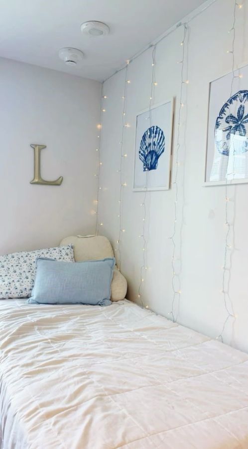 coastal dorm wall with shell art, soft fairy lights, and a pastel color palette