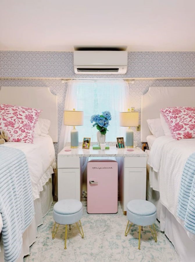 cute dorm setup with pastel pink pillows, blue bedding, and girly coastal touches