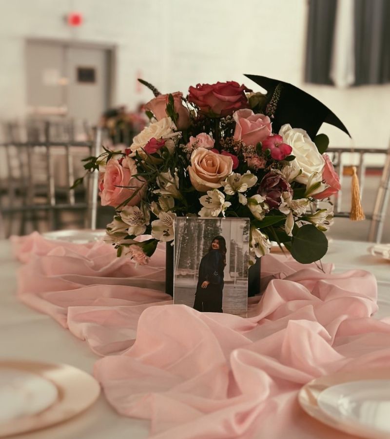 pink graduation party centerpiece with grad photos and florals 