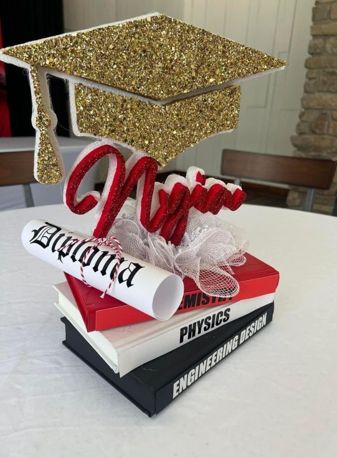 grad party books centerpiece with sparkly gold graduation cap and diploma