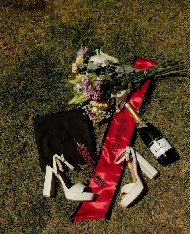 graduation cap gown and heels on grass