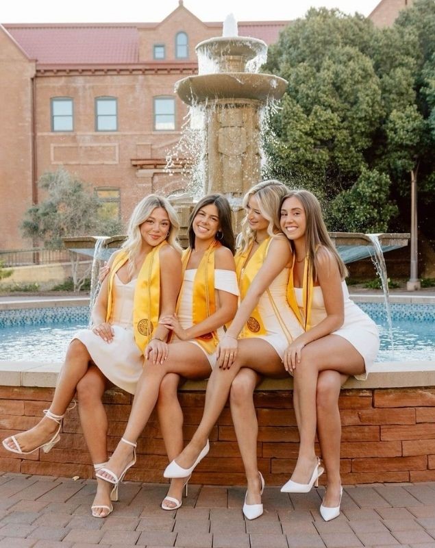 3 grad girls sitting by the fountain