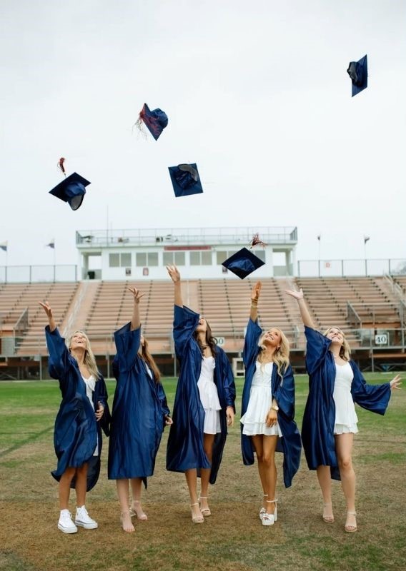 4 grads tossing cap in the air