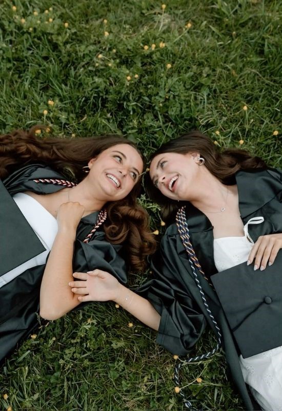 2 grad girls laying on the grass