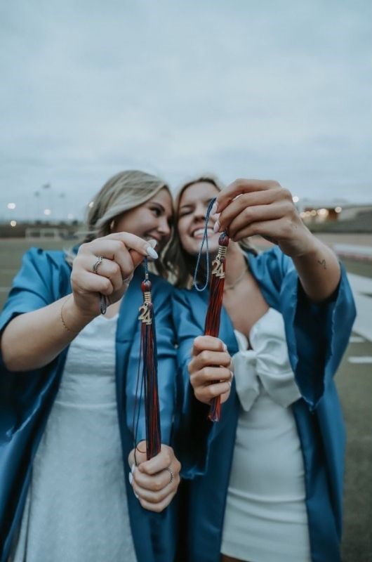 2 grad girls holding tassels